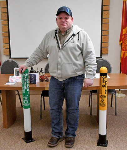 Scott Barry, a damage prevention supervisor for Tallgrass, stands between two pipeline marker pillars he brought to a meeting of the county Local Emergency Planning Committee (LEPC)last  Wednesday. The marker on the left is green and marks a line that carries carbon dioxide and the marker on the right is yellow which represents the presence of a natural gas pipeline. 