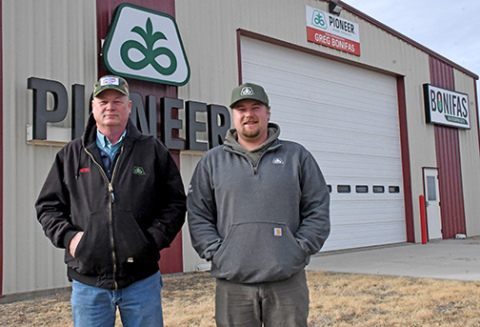 Pioneer seed representative Greg Bonifas, left, and his son Grant, stand out front of their facility north of Aurora along Highway 14. Bonifas celebrated his 25th anniversary with the company last year and is helping Pioneer celebrate its 100th anniversary in 2026. 