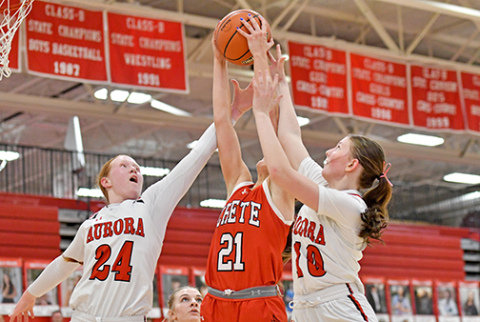 Aurora’s Evelyn Kraus (24) and Kenna Merrihew (10) battle for an offensive rebound sandwiched with Crete’s Kassidy Egge.