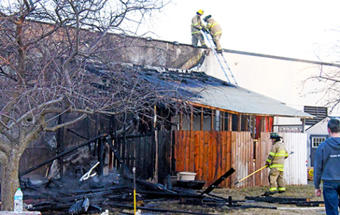 Aurora firefighters check the roof of the Edgerton Explorit Center after an early morning fire on Friday destroyed the raptor enclosure attached to the back of the building. 
