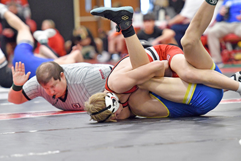 Carson Krejci, shown above getting the pinfall win, was one of three gold medalists for the Huskies at Saturday’s Central Conference tournament. At right, Logan Svoboda became a three-time conference champ with his tournament win Saturday. 