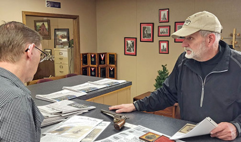 Auctioneer Steve Gerritsen (right) shows ANR Co-publisher Kurt Johnson a few of the hundreds of historical items he has up for sale in an online auction. A number of the lots have connections to some of Hamilton County’s earliest residents. 