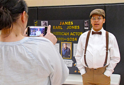 Samuel Njuguna performs as American actor James Earl Jones while his mother, Cora records his presentation.