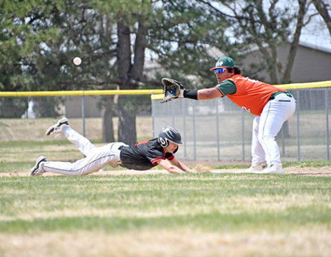 News-Register/Richard Rhoden Aurora’s Jack Carstensen dives back to first base to avoid the pickoff during the Huskies’ 12-0 win in game one over Maxwell St. Pats Thursday. The Huskies picked up two wins that day over Maxwell, including a wild 16-12 victory in game two. 
