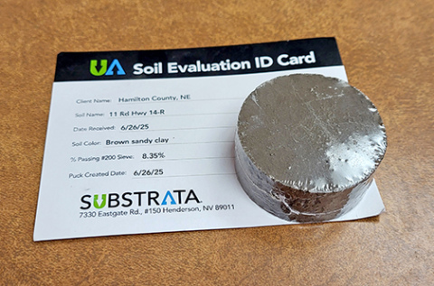 County Highway Supt. Jeremy Brandt sent a sample of the material dug from about six inches below the surface of 11 Road to Substrata, the Nevada company that manufactures Perma-zyme, and received back this shrink-wrapped puck made from the sample by adding the ezyme to it. It appears to be as hard as concrete. 