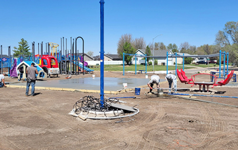 Workers pour a concrete walkway that will go through the middle of the Hamilton County Inclusive Playground. At right in the background is the framework for the zipline that will allow disabled children to ride next to their able-bodied friends. 