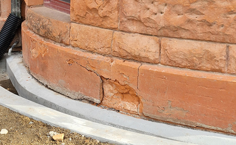 These deteriorating foundation stones on the curving bow bay window portion of the south side of the courthouse will be replaced soon following action by the county commission on Monday. The Colorado sandstone blocks have been weakened by water that has seeped into them over the years. That problem is being corrected by the concrete ground level gutter system that is being installed and which can be seen at the bottom of the photo. 
