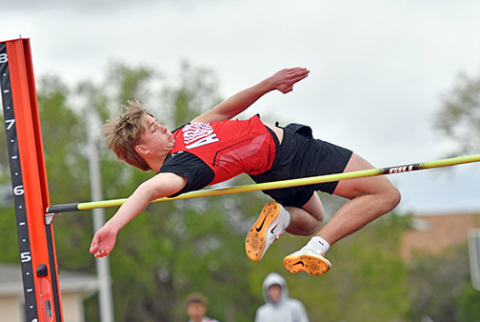 William Evans twists over the high jump bar, finishing third with a mark of 5-8. 