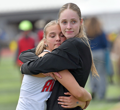 Stella Peterson (left) and Kaitlyn Staehr hug it out after finishing fifth and second respectively in Thursday’s triple jump event. 