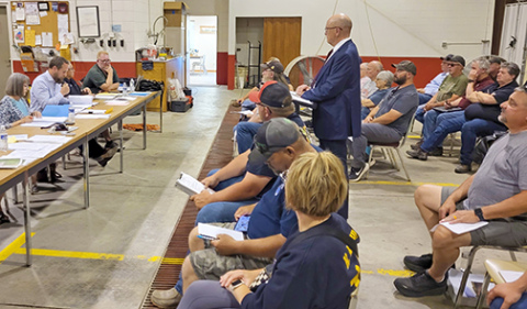Gothenburg attorney Mike Bacon (standing) addresses the Phillips Village Board meeting as the Community Development Agency, to present a request for TIF financing for six new rental units proposed to be built by Bartunek 3D Enterprises. 