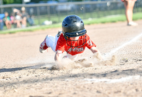 Walker Griffith goes all-out with an aggressive head-first slide into home plate. 