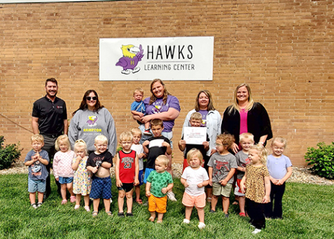 Children and staff members of the Hampton Community Daycare Center line up for a photo after receiving a $500 Community Contest Award. 