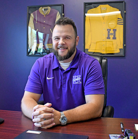 Carson Klute sits at his desk in the superintendent’s office at Hampton Schools a few days before the start of the new school year. The Hampton High School grad took over the position July 1 and said he was looking forward to the new school year. Klute’s family history at Hampton is evidenced by his grandfather Fred Klute’s Hawks letter jackets on the wall behind him. His father’s Hampton High School diploma hangs on another wall. 
