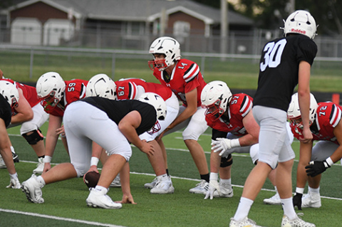 Sam Jones (14), who is expected to share time under center with senior Wyatt Pollet, takes a snap with the No. 1 offense during Friday’s final preseason scrimmage.