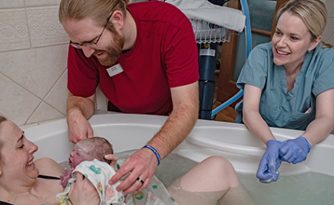 Elizabeth Mollard (right) assists with a water birth at St. Elizabeth Regional Medical Center in Lincoln on March 10, 2022. (Photo by Leslie Moon/Novita Birth Stories)