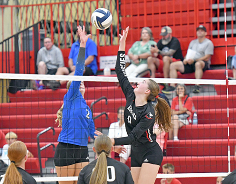Aurora’s Elizabeth Luebbe and Malcolm’s Payton Dolliver go for the same ball at the top of the net in what was a three-set winner for the Huskies. 