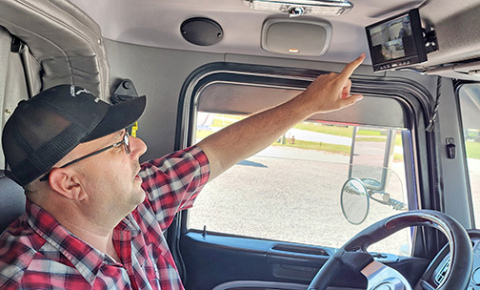 Acord Transportation Regional Manager Mike Bronzynski points to the monitor in the cab of his truck that shows the views of the four different mounted cameras offering various views of the road and the trailer both behind and ahead. 
