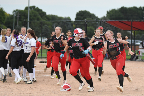 Vivi Fahrnbruch, right, and her teammates prepare to celebrate after a run-rule victory over Fillmore Central. In Aurora’s four games last week, the Huskies plated 49 runs, all victories. 