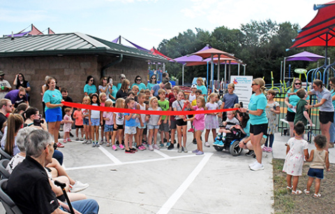 A group of children prepares to cut the ribbon to officially open the Hamilton County Inclusive Playground on Saturday morning. 
