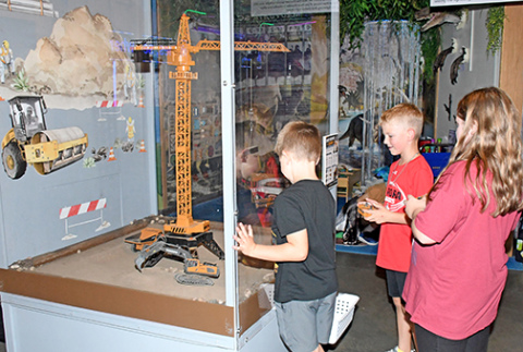 Visitors can move toy vehicles using remote controls in one of the exhibits in Edgerton’s new Build Zone. Pictured from left are Hayes Beins, Calvin Shannon and Destiny Almont.