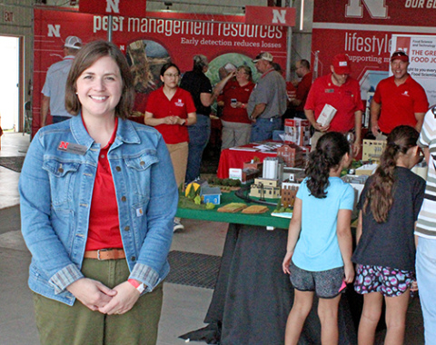 Extension Educator Jordan Grummert Rassmussen stands inside the Big Red Building at the recent Husker Harvest Days where various Extension booths were located. Rassmussen is the program area leader for Rural Prosperity Nebraska, an Extension program that helps rural communities develop new leaders and plan for the future. 