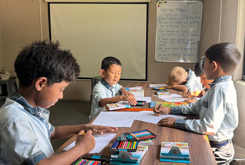 The Dream School is working with their students and families to help assemble 300 backpacks containing school supplies for children who lost their belongings. Students at The Dream School are pictured here creating cards to include in the backpacks.