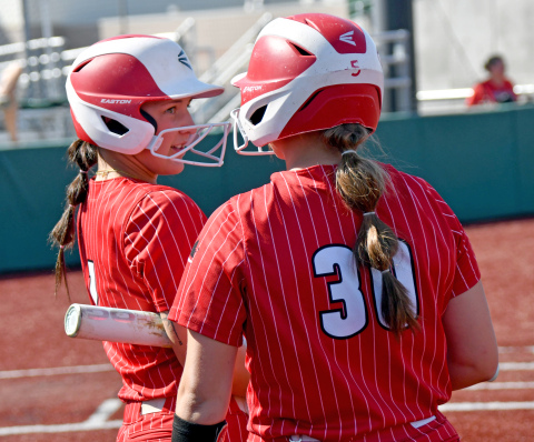 Londyn Teahon (1) and Makaylah McCartney chat before their at-bats during Aurora's loss to York in Thursday's district contest. 