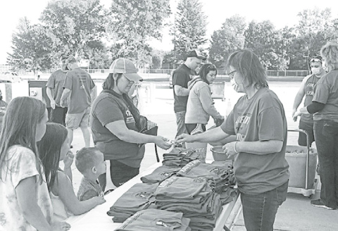 Penny Evans (right) sells “Coleton Strong” shirts at the Phillips Memorial Hall to help raise funds for the family’s medical costs. News-Register/Jeni Moellenberndt