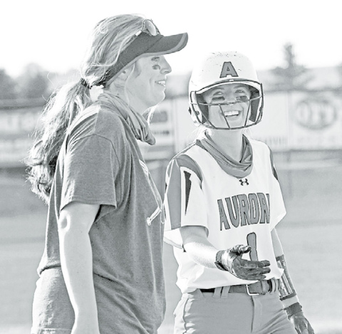 Aurora senior Kylie Larson shares a light moment with Aurora coach Ashton Voss after sliding safely into third base during the Lady Huskies’ 10-3 win over Holdrege Thursday. News-Register/Richard Rhoden