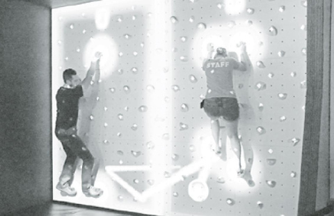 Edgerton Mad Scientist John Boeder (left) squares off against educator Nicole Havlik on the Edgerton’s popular augmented reality climbing wall. There are often new games to enjoy. News-Register/Cheyenne Rowe