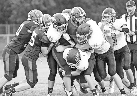 A swarm of Hornet defenders aim to bring down Heartland’s Nolan Boehr during Giltner’s 72-26 loss to the Huskies in the season-opener Friday night. News-Register/Richard Rhoden