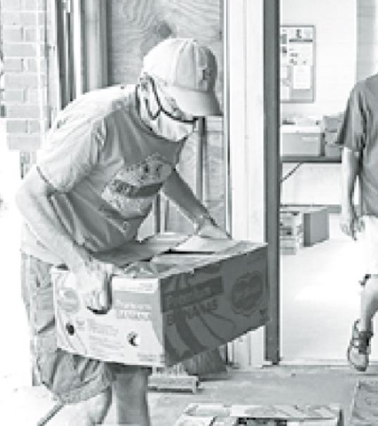 Bruce Ramsour (left) and Craig Ratzlaff help to unload the food donated by Catholic Social Services. News-Register/Cheyenne Rowe