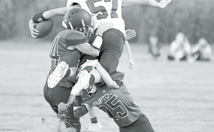 Above: Tackling was key through most of the night for Hampton as Andrew Adams (left) and Austen Adams combine for the stop. At right, Evan Pankoke (24) comes in to wrap up as Tyson Wolinski hangs on for dear life. News-Register/Richard Rhoden
