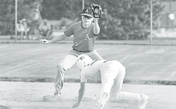 Aurora Cooperative Red shortstop Jayson Havens fields a perfect throw from home plate and slaps the tag on Pinnacle Bank White’s Trevor Moeller during Thursday’s 7-1 win. News-Register/ Richard Rhoden