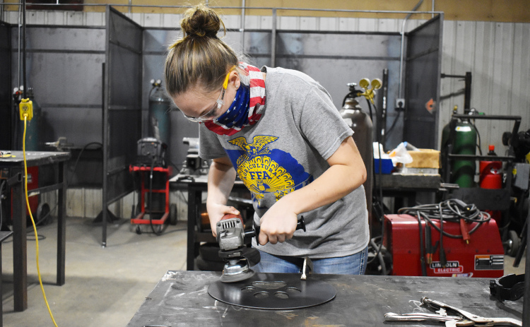 Sydney Lindburg works on a sign that she created.