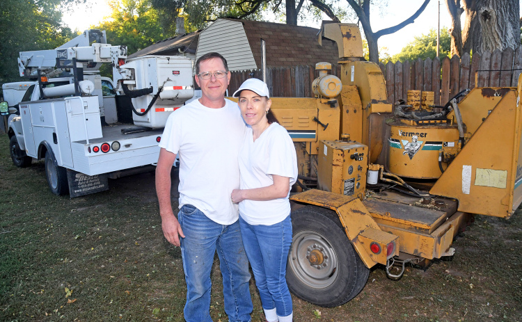 John and Jeannie Wilkinson stand beside the boom truck and wood chipper machine purchased recently to help launch their home-based JNJ Tree Service business.
