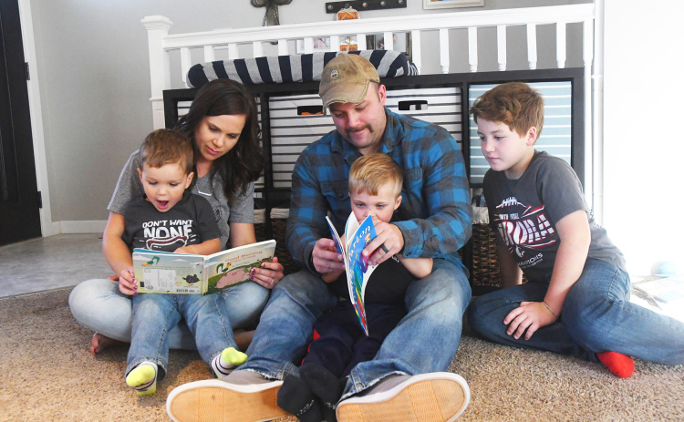 Becca Greenough (left) and son Alex Greenough read about farm animals while Tanner Greenough  and son Camden Greenough learn their colors. Big brother Tristan Greenough watches story time.
