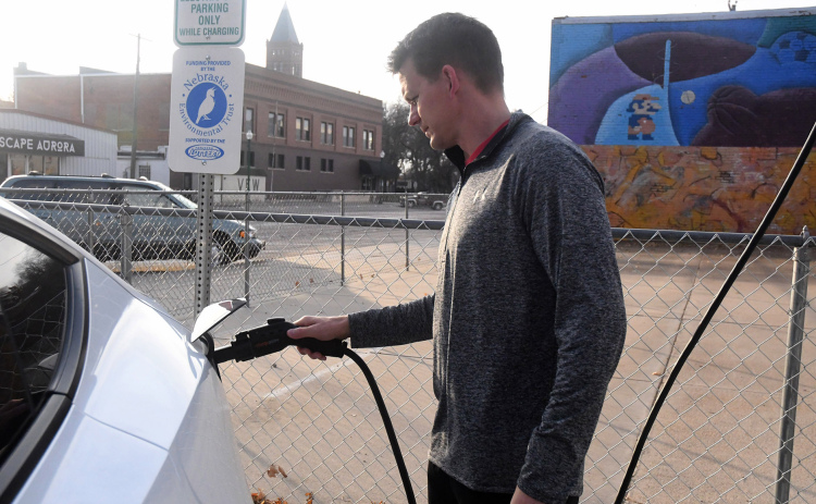 Chad Carlson plugs his electric vehicle into the newest charging station just north of the Youth Center.