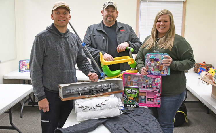 From left, Grant Hill, Scott Snider and Vicki Hill stand with some of the donated toys, clothing and other items for the free shop they will be hosting Saturday.