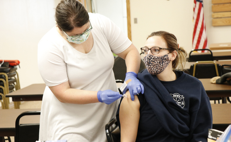 CDHD worker Kamrie Peterson, left, administers one of a limited number of Pfizer COVID-19 vaccines to Aurora Fire and Rescue’s Sara Newton.