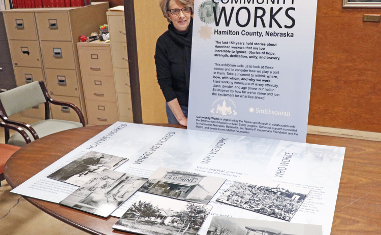 Tina Larson, executive director of the Plainsman Museum, stands proudly with some of the panels that will be on display for their Community Works exhibition.