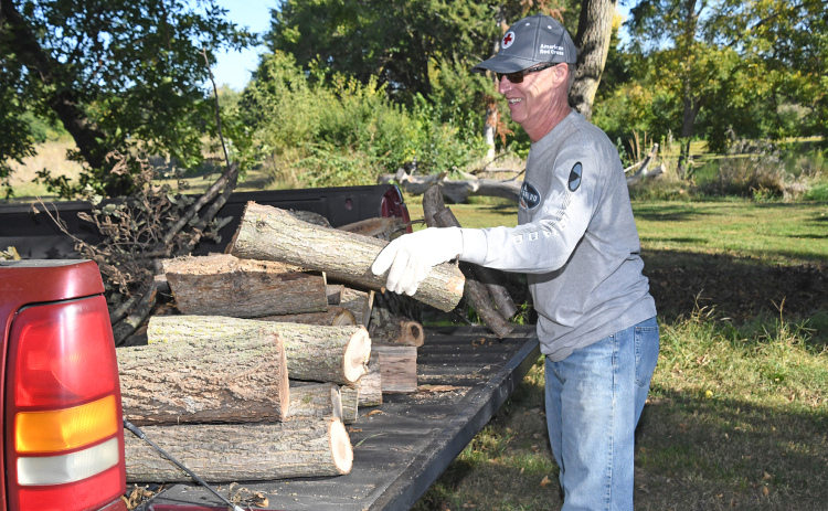 Paul Lackore loads cut lumber into a pickup as one of many Aurora United Methodist Church volunteers lending a helping hand by clearing the grounds at The Leadership Center.