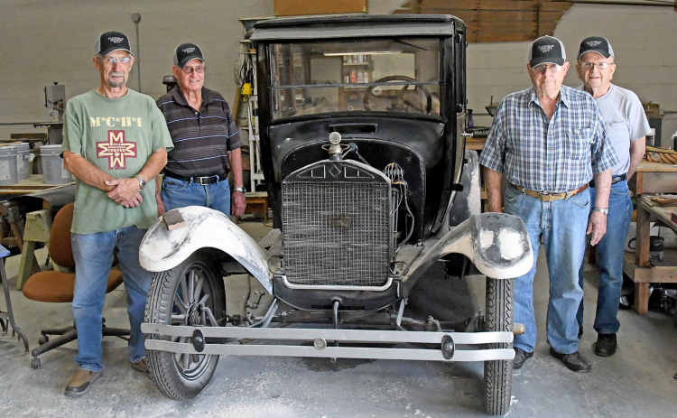 From left, Dale Saddler, Don Bish, Gary Bayne and Walt Jacobs stand together by their current project at the Plainsman Museum. This group of volunteers has been working on restoring vintage vehicles for the museum.