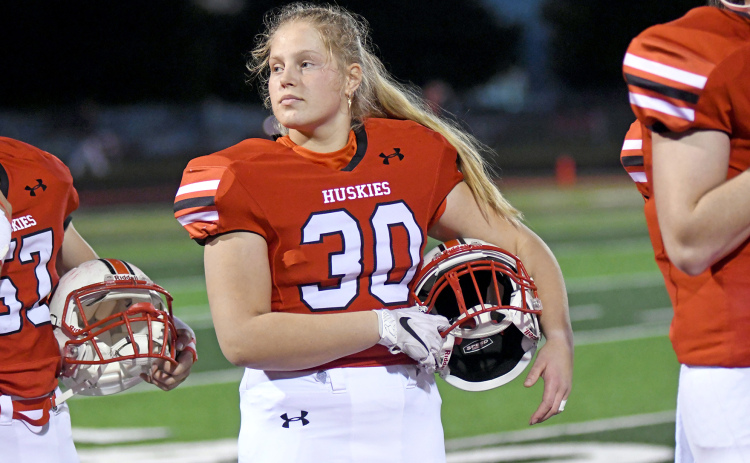 Tia Teigre, a foreign exchange student from Norway, stands in formation as the Aurora band plays the National Anthem before the Lexington game Friday.