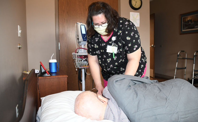 Barb Morris, an LPN and MDS coordinator at Westfield Quality Care in Aurora, takes the blood pressure of Wayne Hilder, a resident at the long-term care facility on 1st Street.