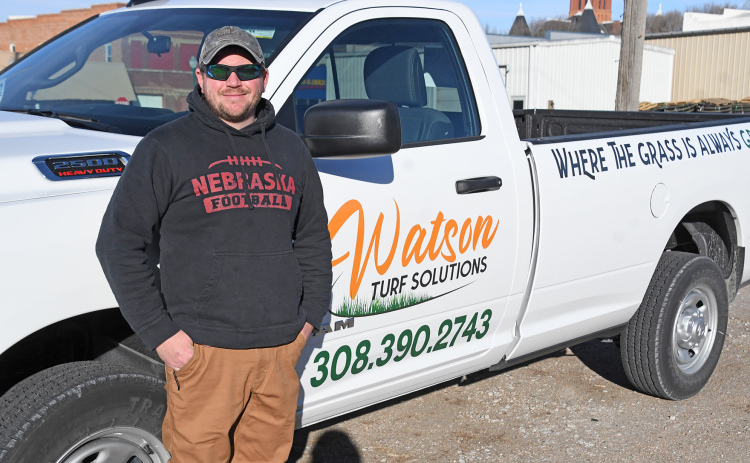 Jordan Watson stands by his new “mobile office,” a pickup featuring his new Watson Turf Solutions logo. The Aurora graduate has worked for other lawn care companies for 17 years and decided last fall to start his own business.