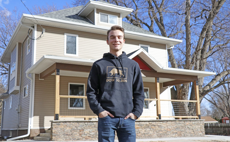 Aurora High School senior Jeremy Hunter stands in front of one of his many wholesale houses,  sold to and renovated by Alan Nunnenkamp.