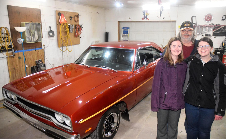 Allan Coats poses with his daughters Tori and Alex in front of the 1970 Plymouth Road Runner in a garage on their property. Most of the renovation occurred in the garage with Alan receiving help from friends and family.