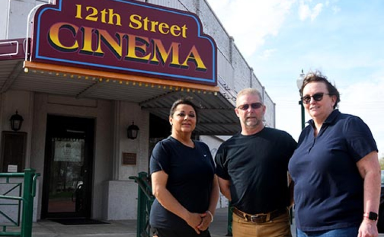 From left: new co-manager Elia Rivera, board president Bruce Hall and co-manager Sheryl Hall stand in front of the 12th Street Cinema. As of May 6 the cinema is showing movies every weekend. Not pictured is new co-manager Monica Lueking.