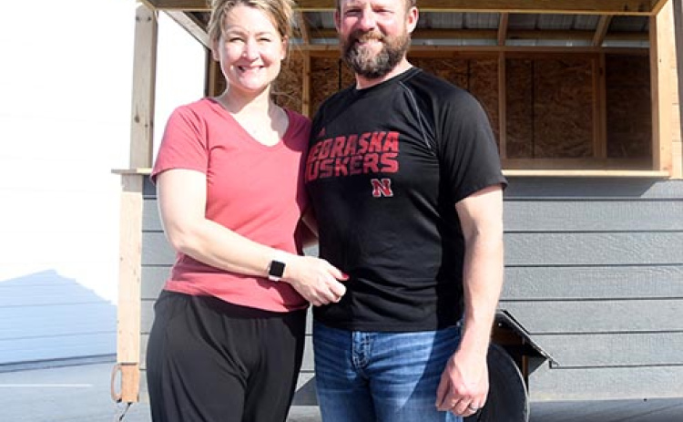 Carrie and Kyle Peterson pose in front of a trailer near their warehouse. The husband and wife partners opened a gardening business on May 5 and will use the trailer to go into town on market days to sell their produce directly to area residents.